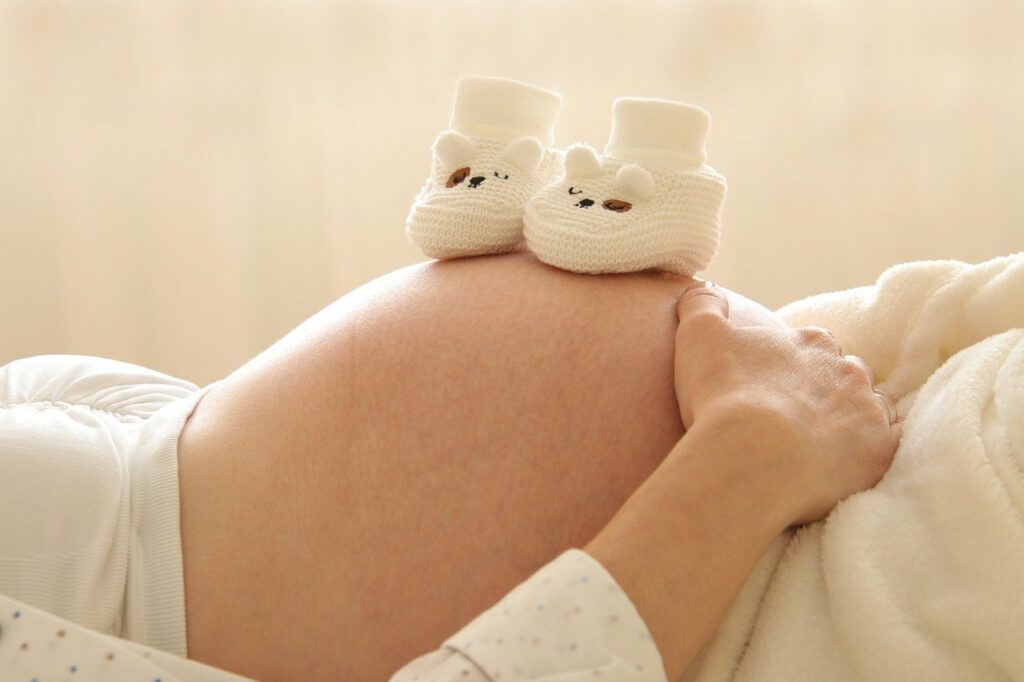 Frau schwanger Babybauch Babyschuhe Geburtsvorbereitung online Jetzt auf die Entbindung vorbereiten